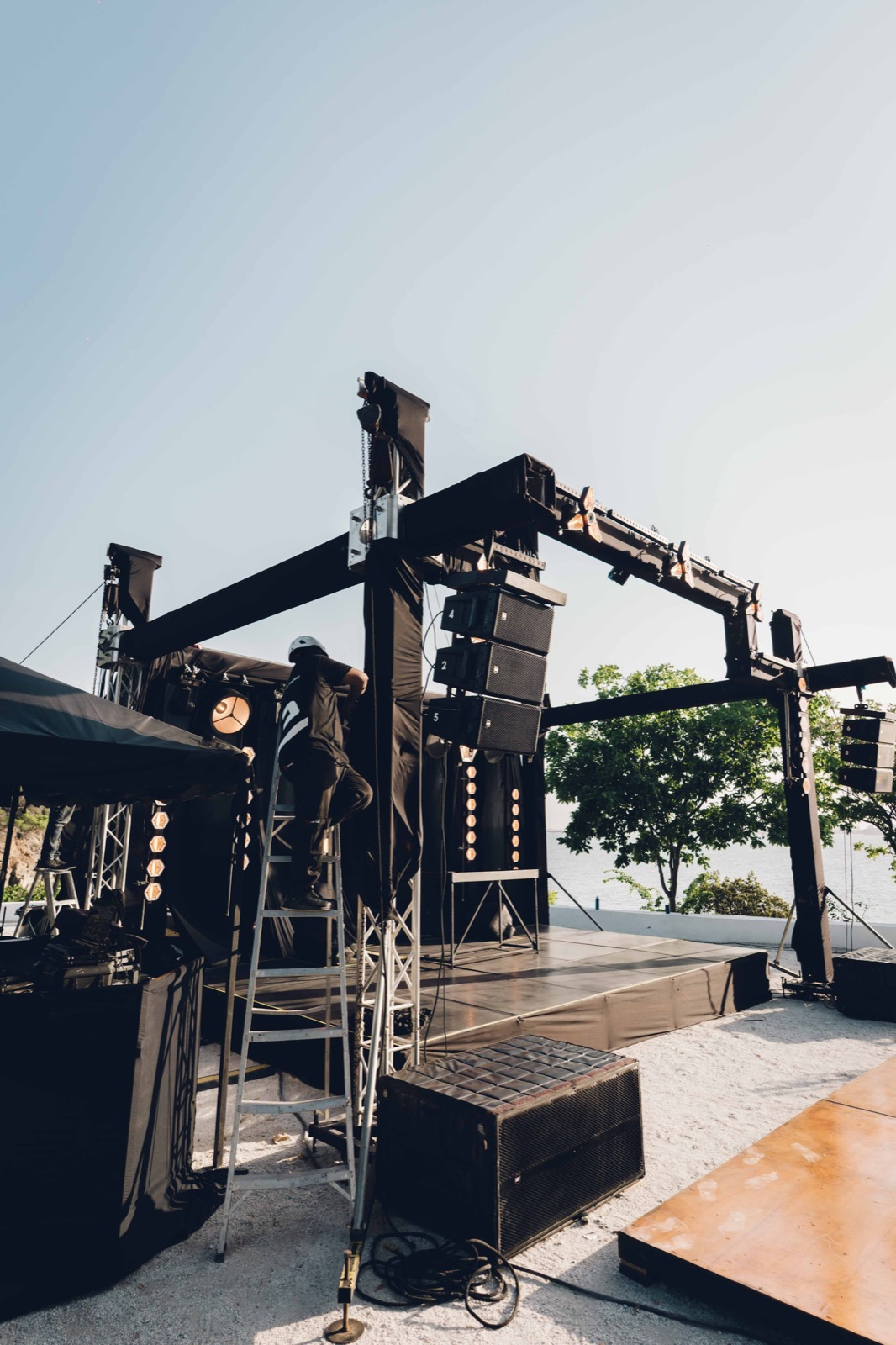 Técnico de Eventor armando un line array de sonido junto al mar